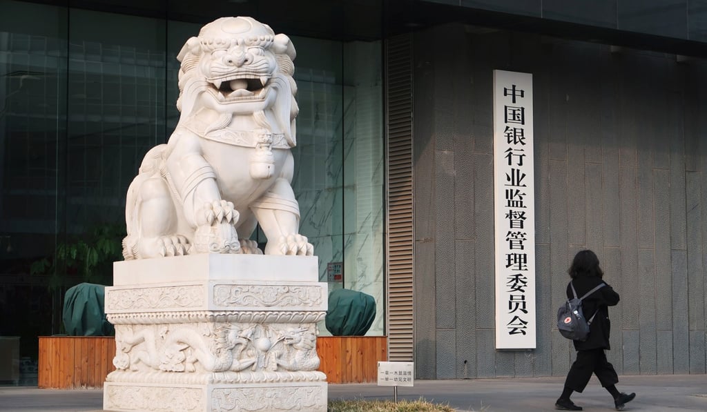 A woman walks past the offices of the China Banking Regulatory Commission in Beijing. To ensure a smoothly running financial system, regulators prefer to see low NPL levels and steady profits. So that’s what banks report. Photo: Reuters