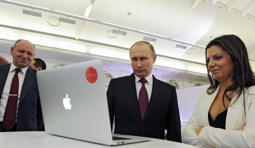 Margarita Simonyan, the editor-in-chief of state-funded RT television network (right) is seen with Russian President Vladimir Putin at an exhibition marking RT's 10th anniversary in Moscow, Russia, on December 10, 2015. Photo: AP