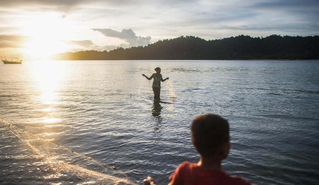 Sea gypsies retrieve a fishing net near Makyone Galet village, in the island chain. Picture: David Dennis