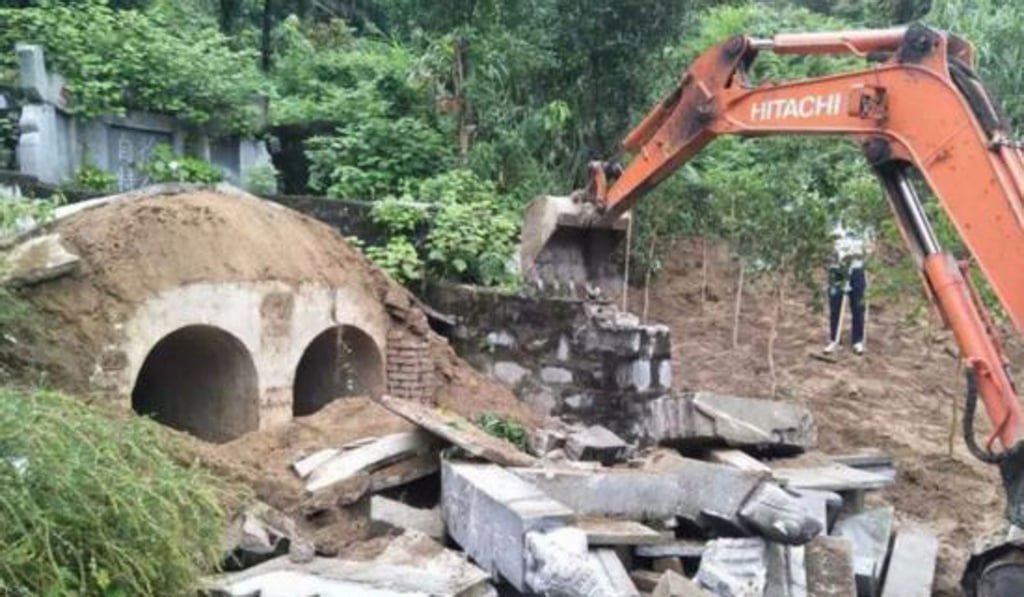 A mechanical digger is used to pull down a tomb. Photo: Aihami.com