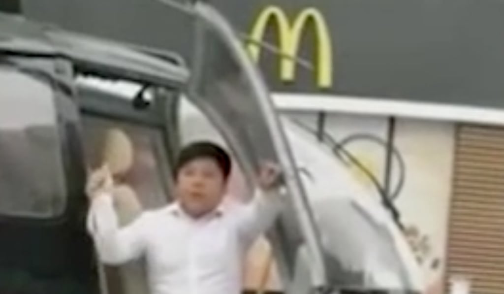 One of the men posing on the helicopter in front of McDonald’s. Photo: 163.com