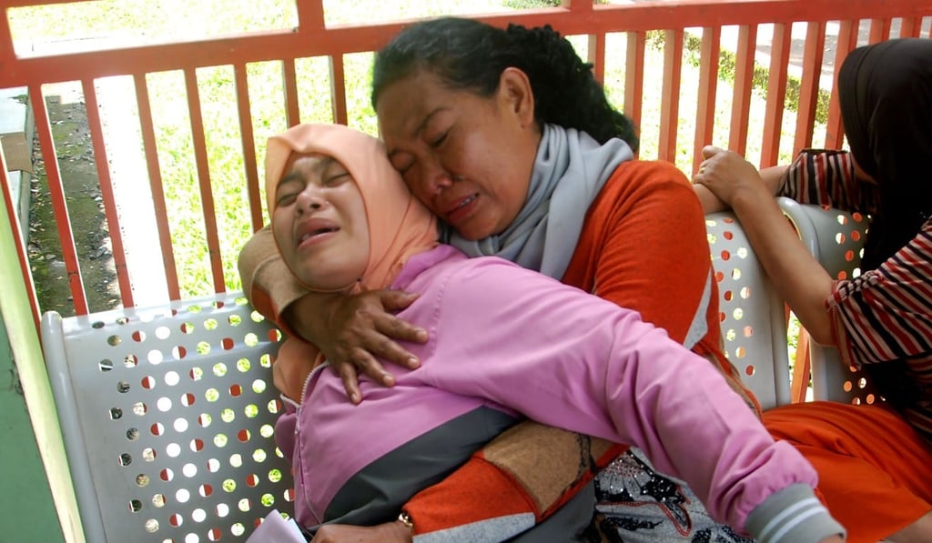 Two Indonesian women break down after their received news that a family member has died from drinking illegal alcohol. Photo: AFP Two Indonesian women break down after their received news that a family member has died from drinking illegal alcohol. Photo: AFP