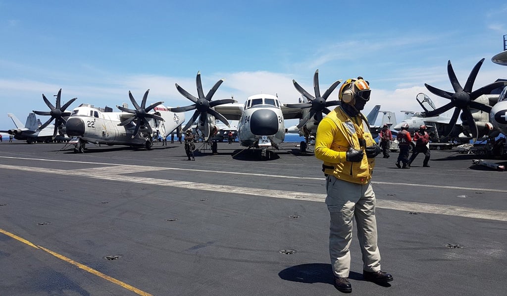 An air traffic controller guides aircraft landing on the deck of the USS Theodore Roosevelt, transiting the South China Sea on Tuesday. Photo: Reuters
