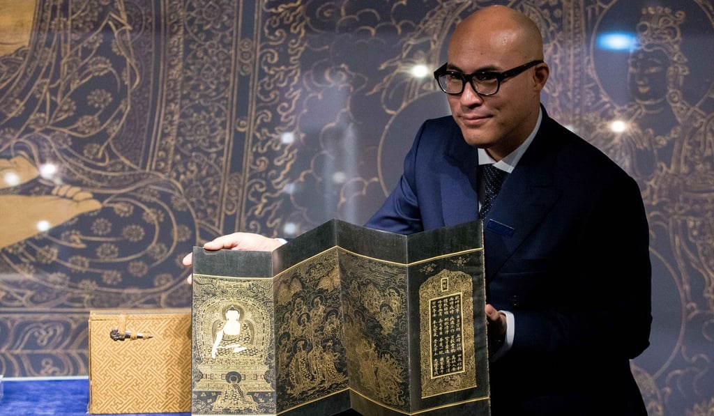 Nicolas Chow, Sotheby's co-chairman in Asia holds two sets of Ming Dynasty Buddhist sutras that sold for HK$239 million on April 3. Picture: Sotheby's