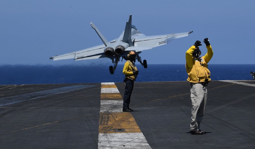 US sailors stand on the flight deck of the USS Theodore Roosevelt while an FA-18 hornet fighter jet takes off on Tuesday. The ship was transiting through the South China sea on its way to the Philippines. Photo: AFP US sailors stand on the flight deck of the USS Theodore Roosevelt while an FA-18 hornet fighter jet takes off on Tuesday. The ship was transiting through the South China sea on its way to the Philippines. Photo: AFP