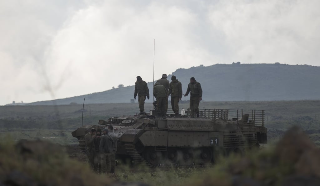Israeli soldiers stand on top of their armored personnel carrier in the Golan Heights, near the Israeli-Syria border in Israel on Tuesday. Photo: EPA-EFE