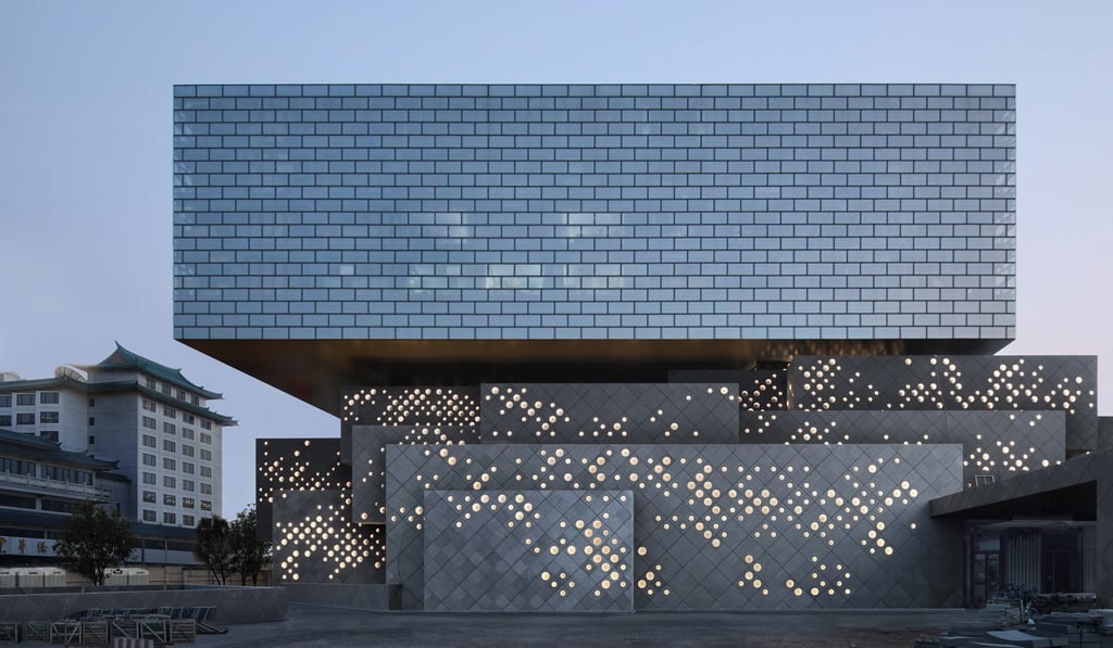 The Guardian Art Centre in Beijing. Grey stone cubes on the ground level are topped by a large rectangular glass box. Photo: Iwan Baan