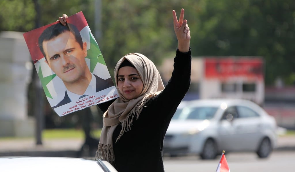 A Syrian woman carries the portrait of President Bashar al-Assad, as she gathers at the Umayyad Square in Damascus to condemn the strikes carried out by the United States, Britain and France. Photo: AFP