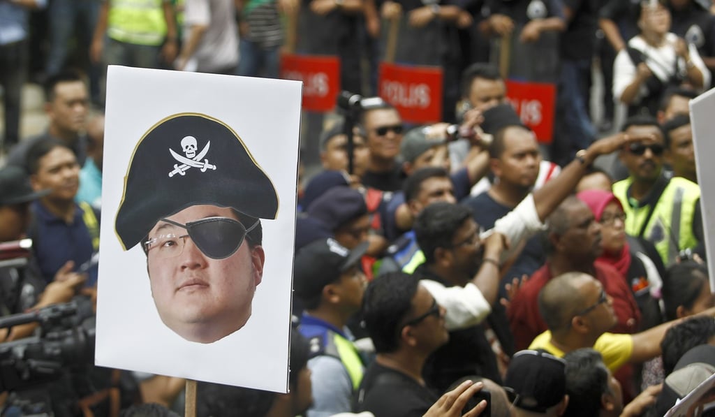 A protester holds a portrait of Jho Low as a pirate during a demonstration in Kuala Lumpur over the alleged multibillion-dollar theft of funds from a Malaysian state investment company. Photo: AP A protester holds a portrait of Jho Low as a pirate during a demonstration in Kuala Lumpur over the alleged multibillion-dollar theft of funds from a Malaysian state investment company. Photo: AP