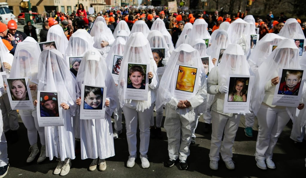 People display portraits of Sandy Hook elementary school shooting victims as they take part in the March for Our Lives, protesting gun violence in schools, in New York on March 24. Photo: AFP