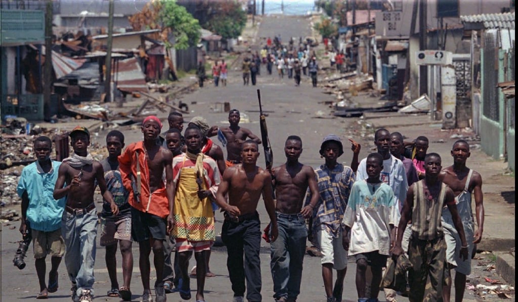 Soldiers loyal to the ULIMO faction move into the deserted streets of downtown Monrovia on May 18, 1996. Photo: AP