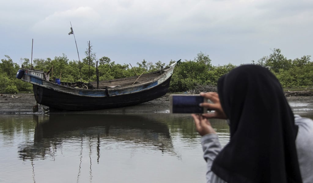 An Acehnese woman takes a picture of the boat. Photo: AP An Acehnese woman takes a picture of the boat. Photo: AP