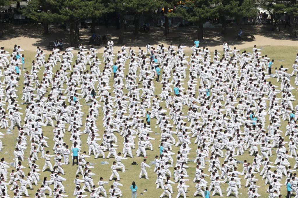 About 8,800 taekwondo martial artists perform poomsae in front of the National Assembly in Yeouido, Seoul. Photo: Yonhap About 8,800 taekwondo martial artists perform poomsae in front of the National Assembly in Yeouido, Seoul. Photo: Yonhap