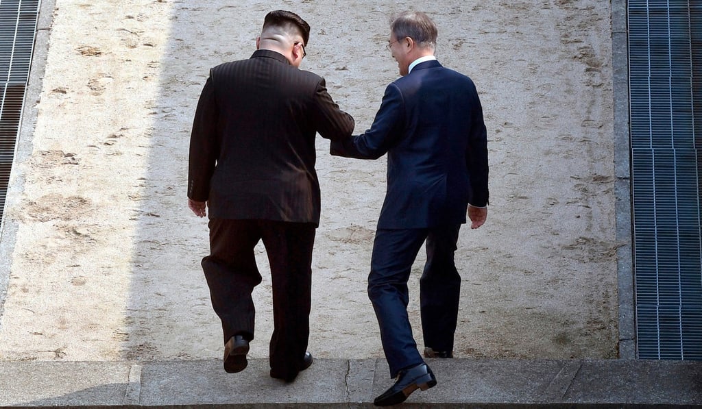 North Korean leader Kim Jong-un and South Korean President Moon Jae-in cross the military demarcation line at the border village of Panmunjom in the demilitarised zone. Photo: AP