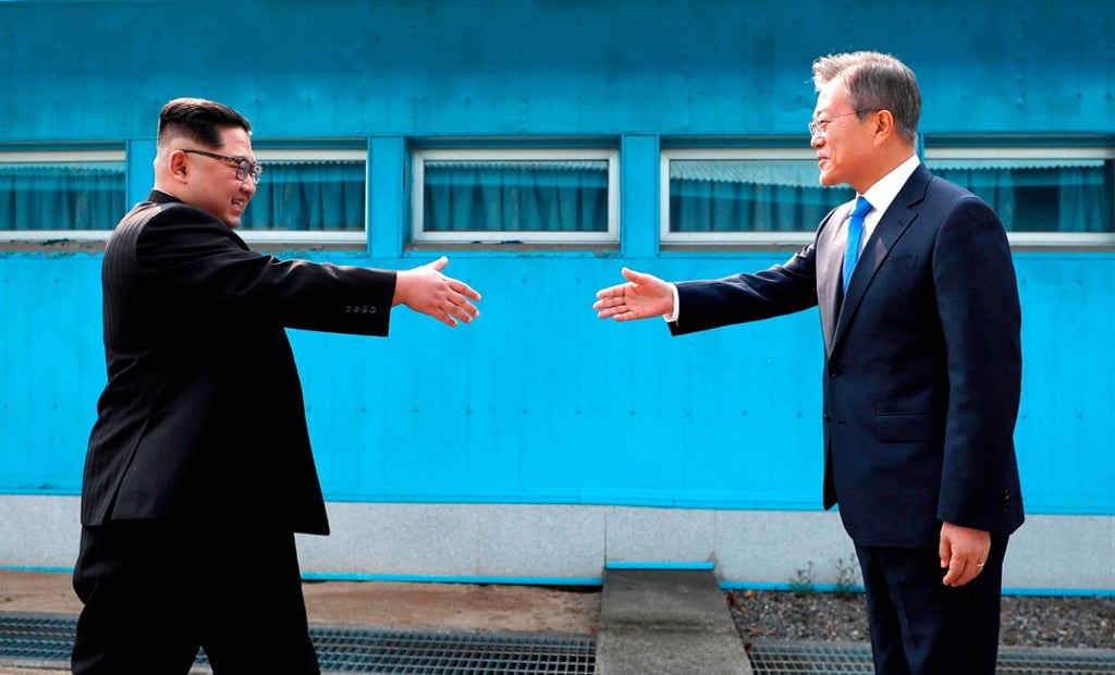 North Korean leader Kim Jong-un and South Korean President Moon Jae-in greet each other over the military demarcation line in Panmunjom. Photo: AP North Korean leader Kim Jong-un and South Korean President Moon Jae-in greet each other over the military demarcation line in Panmunjom. Photo: AP