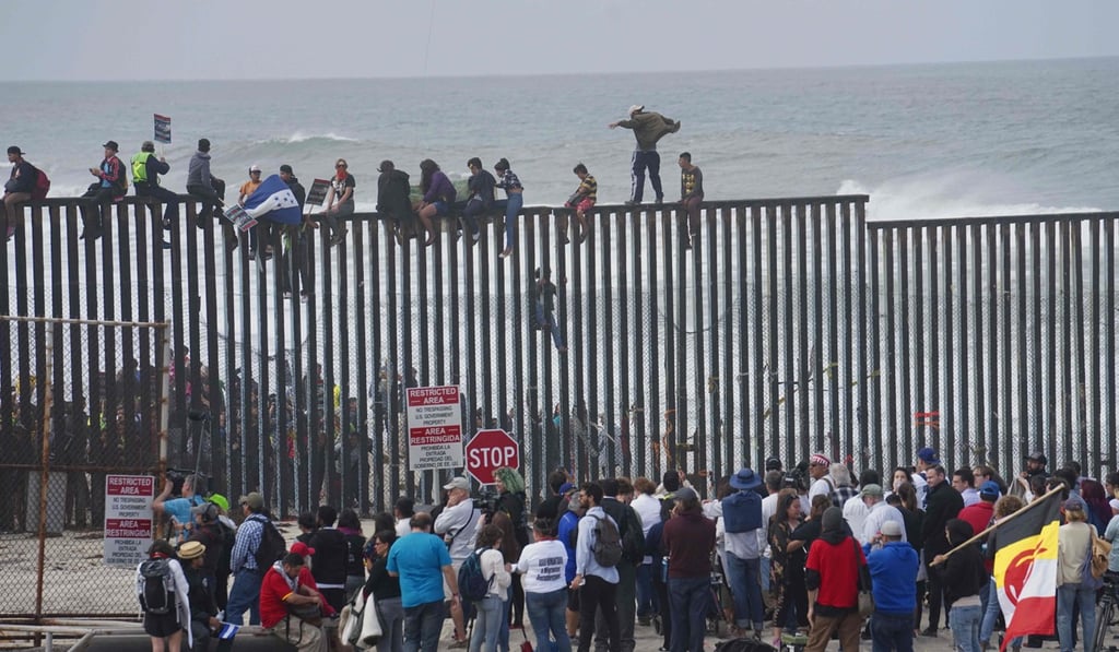 Pro-migrant caravan demonstrators climb the US-Mexico border fence during a rally on hoto: Agence France-Presse Pro-migrant caravan demonstrators climb the US-Mexico border fence during a rally on hoto: Agence France-Presse