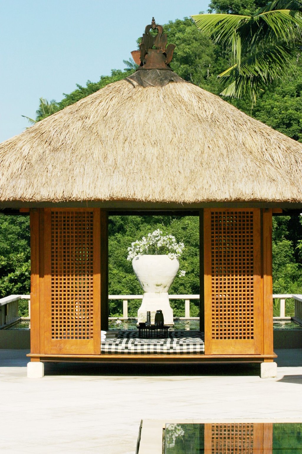 A thatched-roof poolside lounger on a private terrace at Amankila resort in east Bali.