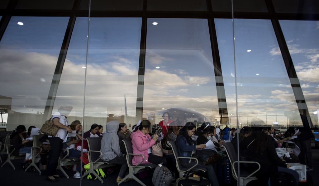 Filipino workers returning home from Kuwait filling out forms upon their arrival at Manila International Airport in February. Photo: AFP