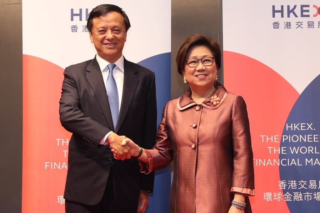 HKEX CEO Charles Li Xiaojia and Chairperson Laura Cha shake hands at a media conference at Exchange Square, Hong Kong on April 26. Photo: K. Y. Cheng