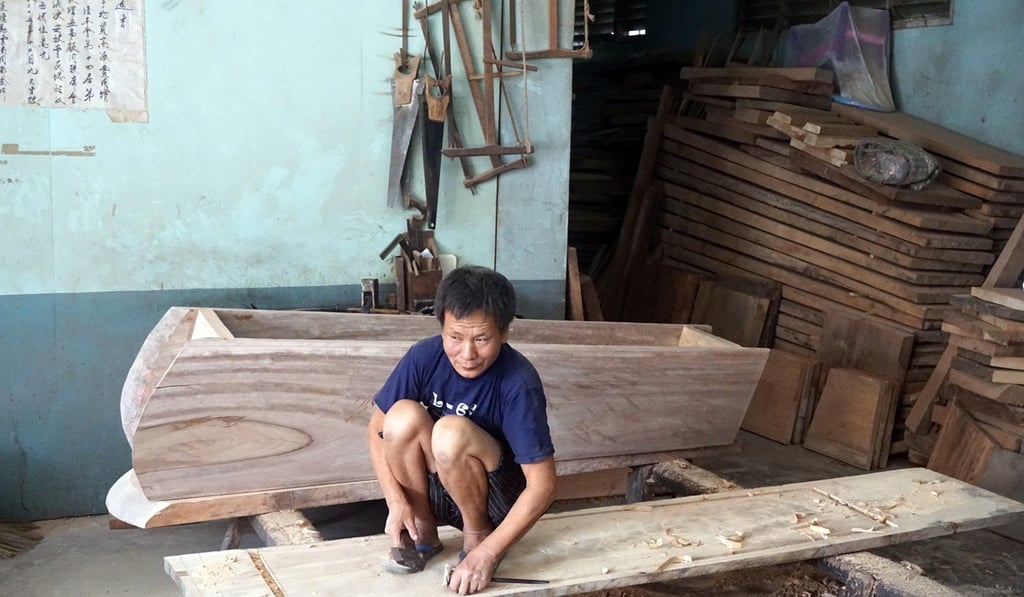 A Chinese worker in a temple fashions a coffin. Photo: AP