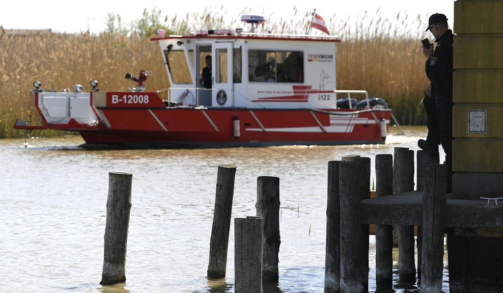 A firefighter boat takes part in a search on Lake Neusiedl while a police officer talks on his radio on April 20. Police found DNA evidence on Alfred U’s cabin on the lake. They subsequently found the entrails of the murdered woman in his freezer. Photo: APA via AFP