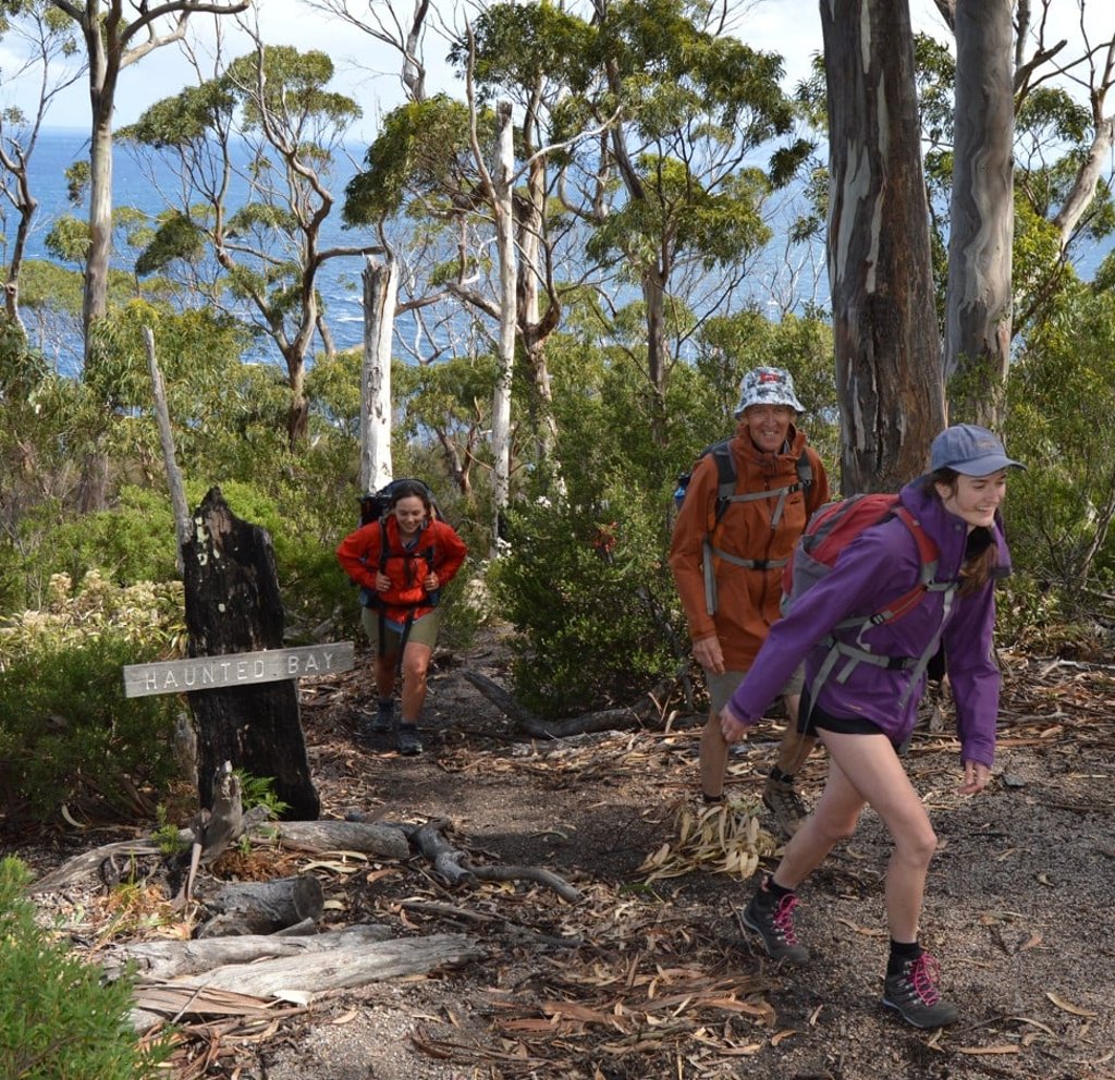 From left: guide Adrien Butler and passengers Leigh and Lily hike Haunted Bay. Photo: Cameron Wilson