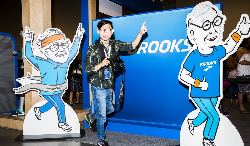 An attendee stands for a photograph with a cardboard cut-out of Warren Buffett. Photo: Bloomberg