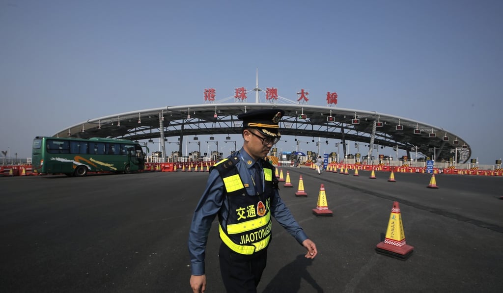 A traffic guard in front of an entrance to the Hong Kong-Zhuhai-Macau bridge. The 55 km bridge is scheduled to start taking traffic later this year. Photo: AP