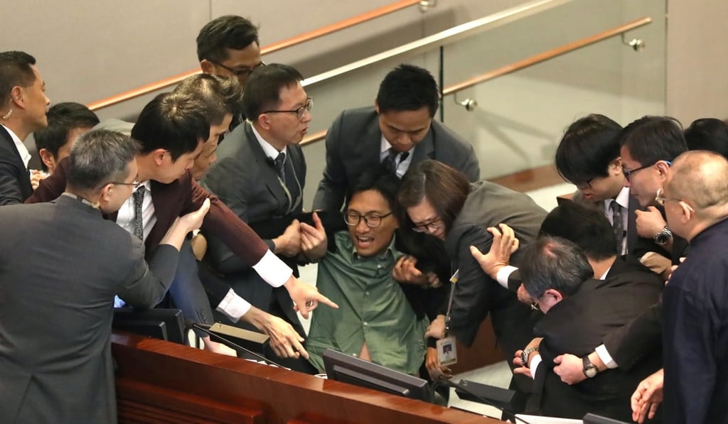 Security personnel drag lawmaker Eddie Chu Hoi-dick out of his seat after Ip ordered his removal from the chamber. Photo: Edward Wong Security personnel drag lawmaker Eddie Chu Hoi-dick out of his seat after Ip ordered his removal from the chamber. Photo: Edward Wong