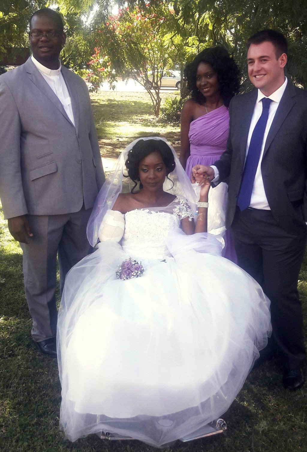 In this photo taken on Saturday, May, 5, 2018, Zenele Ndlovu, centre, and new husband Jamie Fox (right) hold hands on their wedding day at a hospital Chapel in Bulawayo, Zimbabwe. Photo: AP