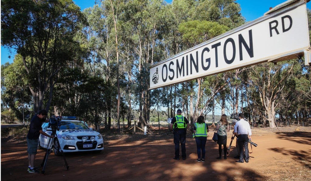 Media film a property from a roadblock set up by police investigating the suspected murder-suicide. Photo: EPA