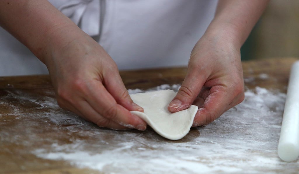 He flattens the dough into a small pancake. Photo: Winson Wong