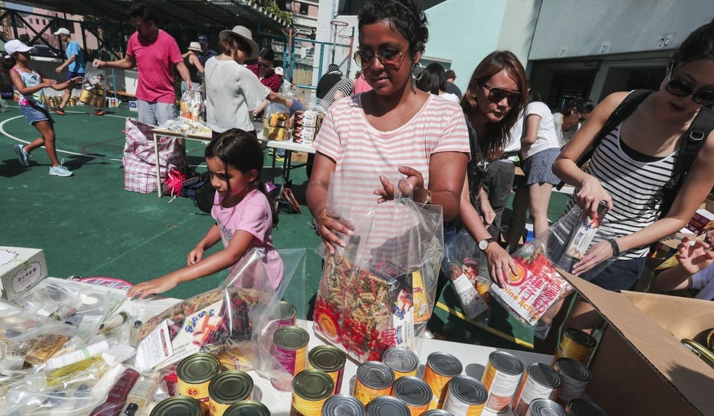 Sharanya Crosbie (centre) and daughter Kaishori Crosbie (left) packing bags of food in Pok Fu Lam. Photo: Jonathan Wong
