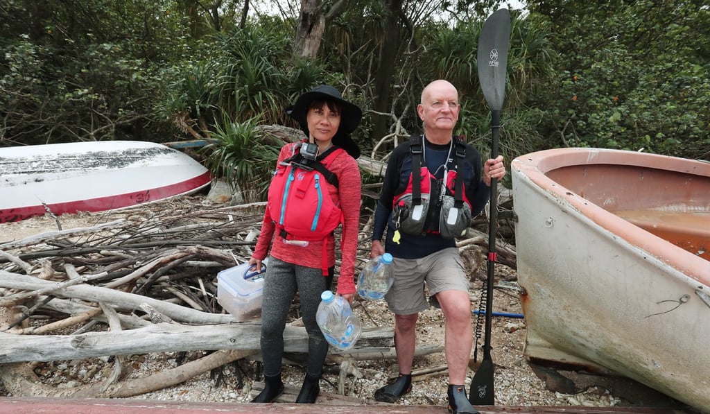 Mary Jean Gaje (left) and David Roche feed and take care of dogs on an island off Sai Kung. Photo: Jonathan Wong