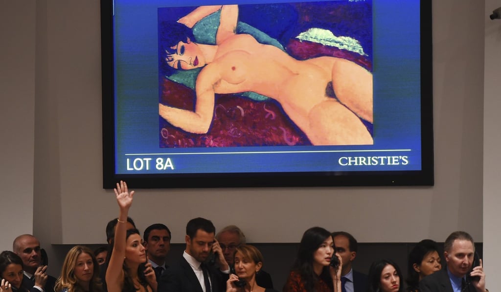 Bid takers stand in front of a video screen showing Amedeo Modigliani's Nu couché, bought at a Christie’s auction in 2015 by Chinese collector Liu Yiqian for US$170.4 million. Photo: AFP