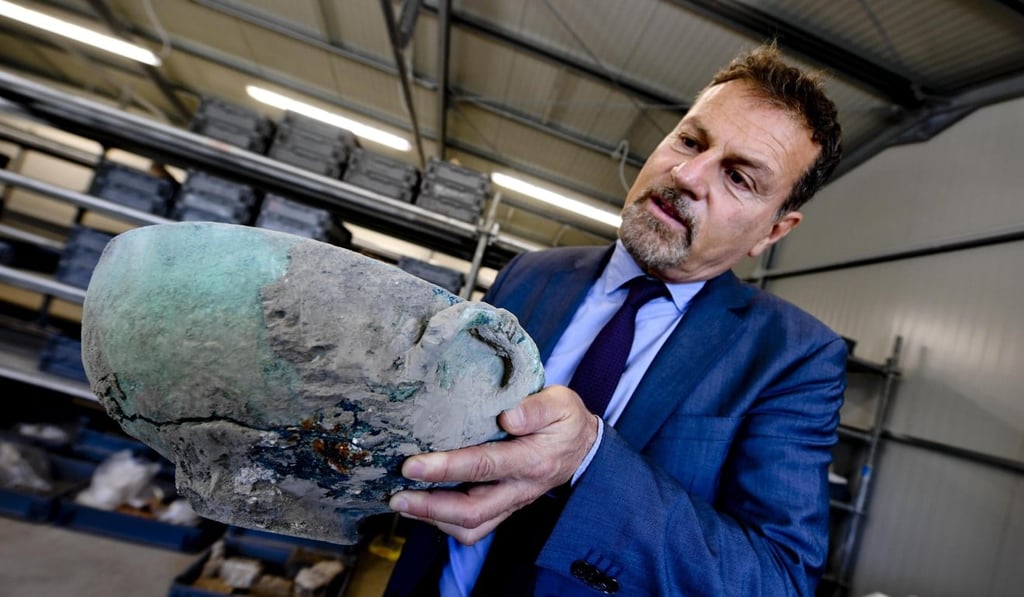 Massimo Osanna, director general of the Pompeii Archaeological Park, shows a bronze vase discovered during excavation works where the “Vicolo dei Balconi” (Alley of Balconies) was recently uncovered in Pompeii. Photo: EPA