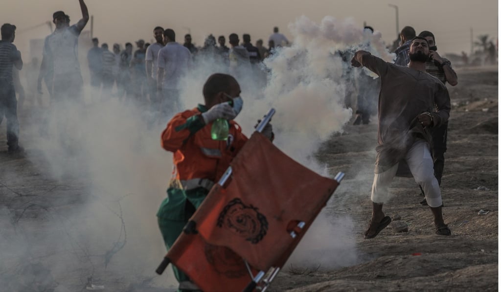 Palestinian protesters hit by Israeli tear-gas near the border between Israel and the Gaza Strip on the same day as the US embassy opening ceremony. Photo: EPA