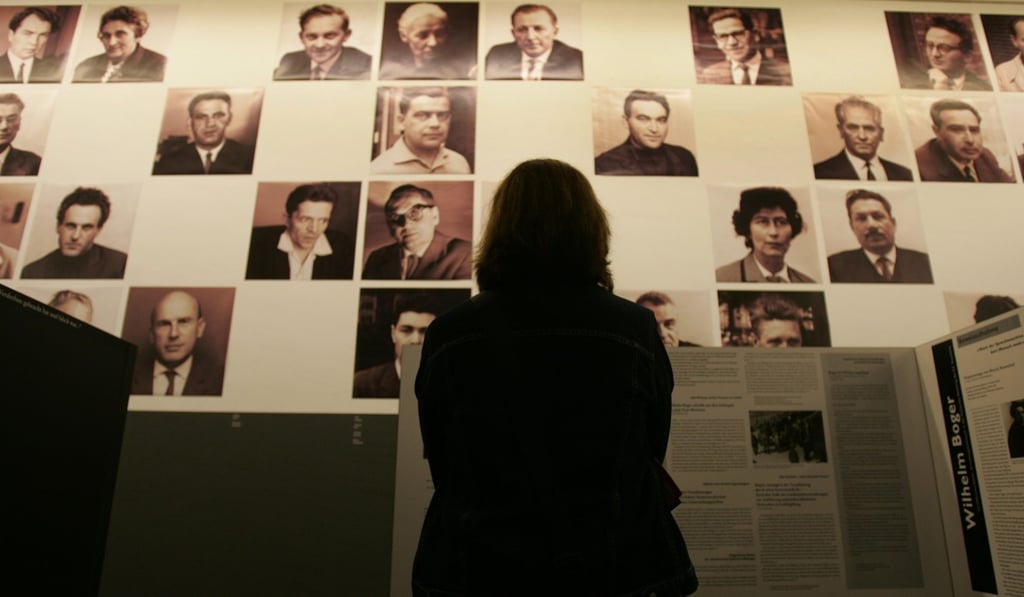 A visitor faces a wall of photographs depicting survivors of the Auschwitz concentration camp who testified in the so-called “Frankfurt Trial”, at the Martin Gropius Museum in Berlin, including previously unreleased sound recordings detailing the proceedings during which Nazi camp commanders at Auschwitz were finally put on trial. Photo: AFP