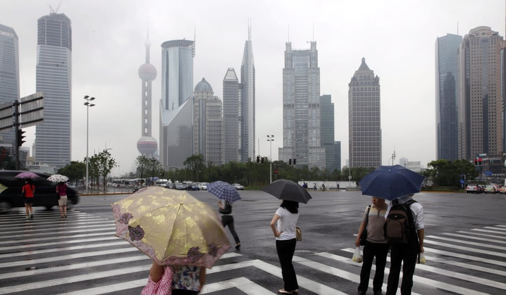 Pedestrians battle against the elements in the Lujiazui Financial District in Shanghai. China’s largest banks are facing a similar tussle to lure wealthy Chinese away from offshore investment banks, says a new McKinsey report. Photo: EPA