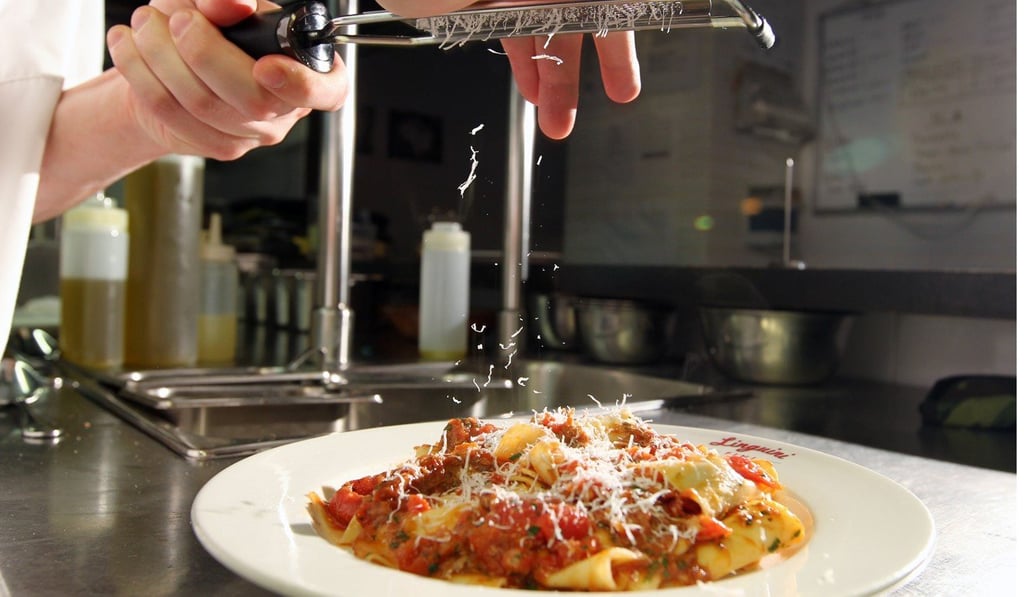 Vinny Lauria, executive chef of Linguini Fini in Hong Kong, grates cheese onto one his pasta creations there. Photo: Nora Tam