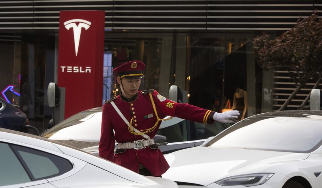 A security guard directs traffic near a Tesla charging station in Beijing on Tuesday. Photo: AP A security guard directs traffic near a Tesla charging station in Beijing on Tuesday. Photo: AP