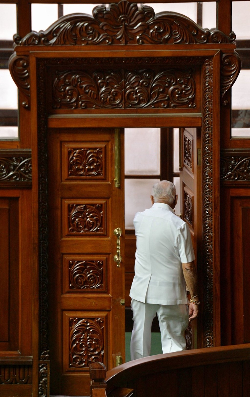 B. S. Yediyurappa of the BJP walks out of the hall of the Legislative Assembly in Bangalore on May 19. He resigned as chief minister of Karnataka state that day, after admitting he did not have enough support to form a government, just before he was to face a vote of confidence in the state assembly. Photo: AFP