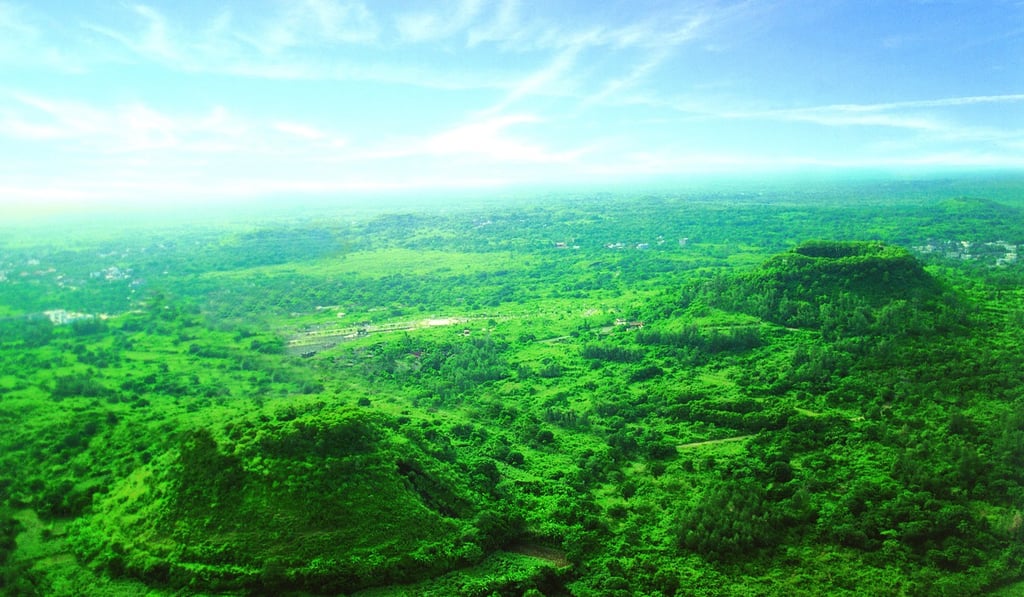 Extinct ancient volcanoes poke out through the lush countryside of the Haikou Shishan Crater Cluster National Geological Park. Extinct ancient volcanoes poke out through the lush countryside of the Haikou Shishan Crater Cluster National Geological Park.