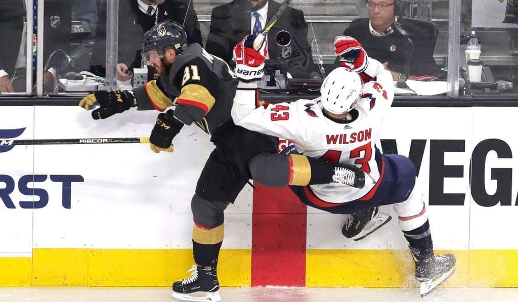 Tom Wilson of the Washington Capitals is checked into the boards by Jonathan Marchessault of the Vegas Golden Knights. Photo: AFP