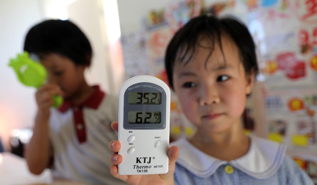 In Chiu Ka-wai, left and Wu Pik-yee’s 250 sq ft home, an illegal structure on top of a 15-storey residential building in Tai Kok Tsui, Kowloon, the indoor temperature was over 34 degrees at around 4pm. Photo: Sam Tsang