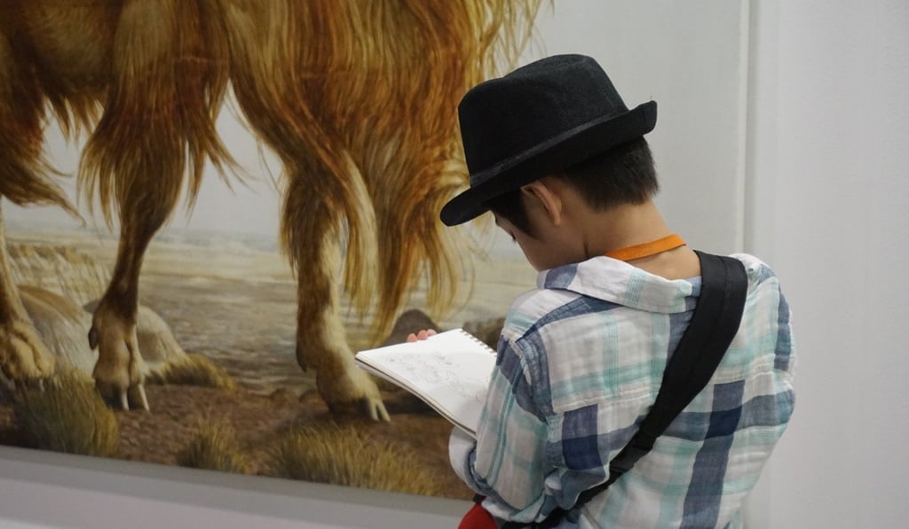 A visitor takes notes at the Hong Kong Art Basel in March. Photo: Hayden Young