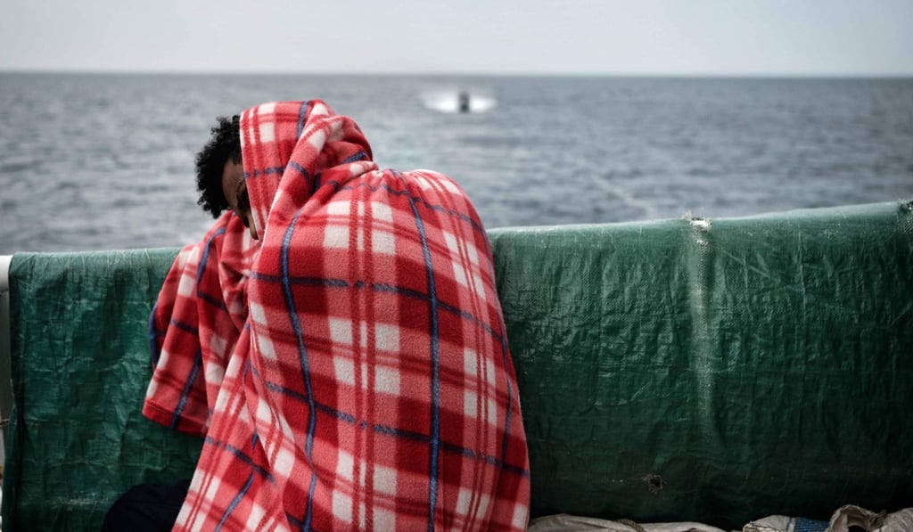 A migrant rests on the deck of the MV Aquarius as it sails into the Sicilian port of Messina. Photo: AFP
