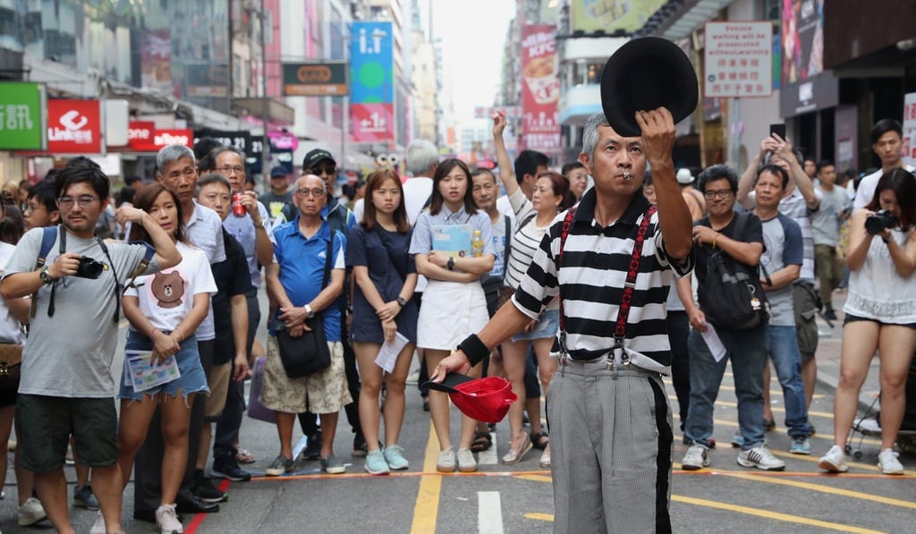 A street performer draws a crowd in Mong Kok. Photo: K.Y. Cheng