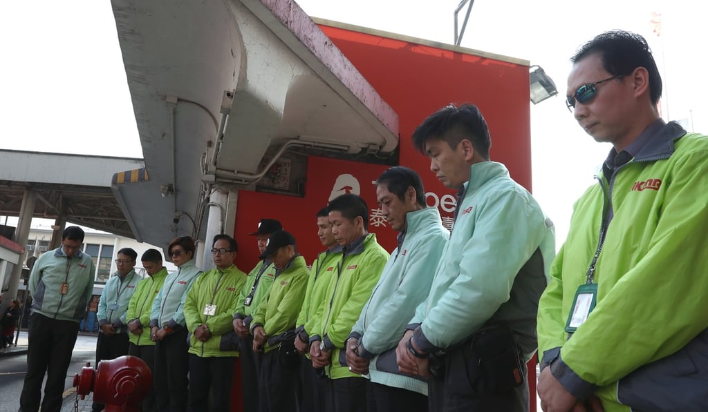 KMB staff observe a moment of silence in tribute to the victims of the bus crash in Tai Po, at the Star Ferry Pier bus terminus in Tsim Sha Tsui on February 12. At least 19 people died and 65 others were injured when a KMB bus No 872 flipped onto its side while negotiating a turn on February 10. Photo: Nora Tam