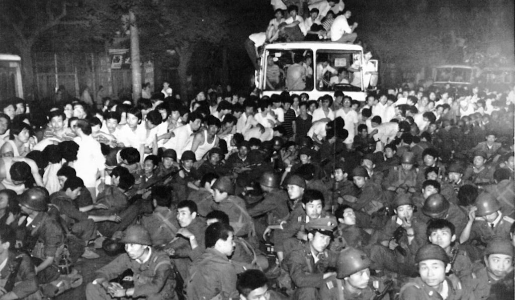Soldiers sit surrounded by protesters on a street near Tiananmen Square late on June 3, 1989. Hours later the troops opened fire. Photo: Reuters Soldiers sit surrounded by protesters on a street near Tiananmen Square late on June 3, 1989. Hours later the troops opened fire. Photo: Reuters